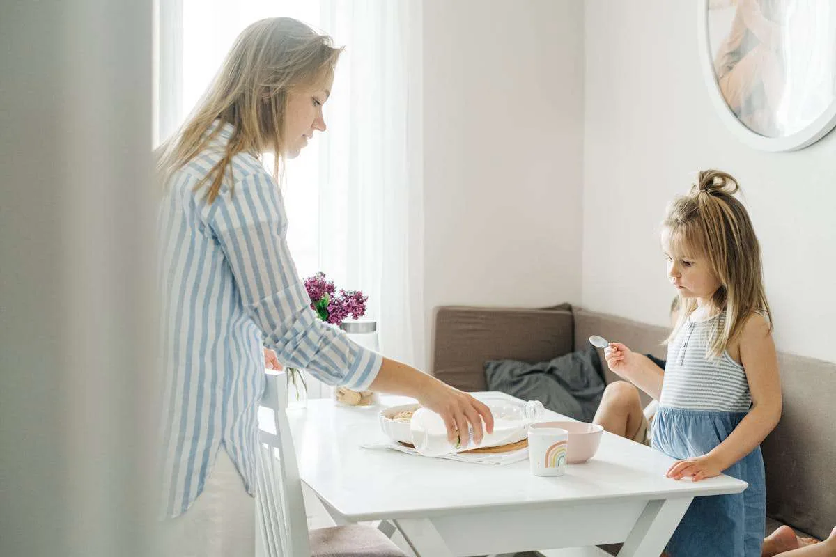 A mother giving her child warm milk based drink.