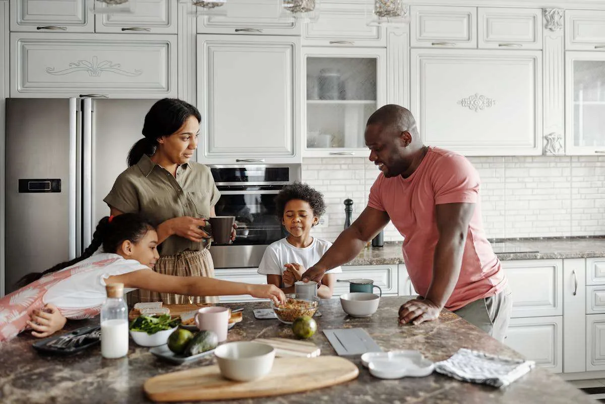 A happy family of kids and their parents enjoying their food.
