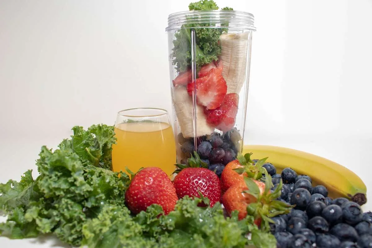 Bananas, strawberries and other fruits in blender for preparing a smoothie.