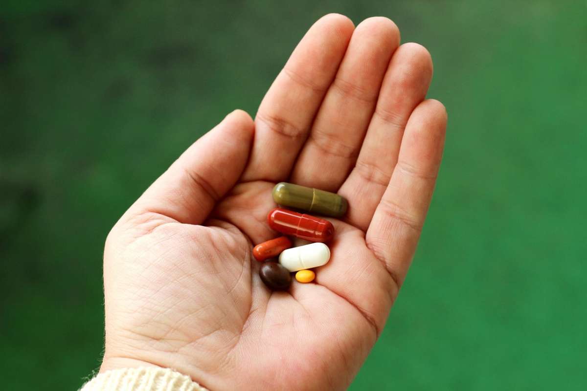 Different types of medication in the palm of a hand.