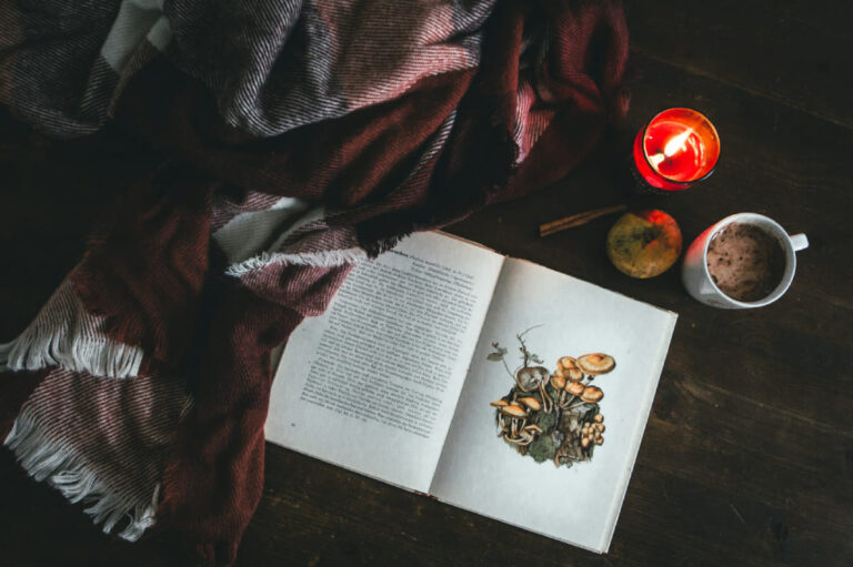 Picture of a mushroom book, Mushroom coffee and candle indicating to the title "Mushroom Coffee: A Low FODMAP Beverage Choice?"