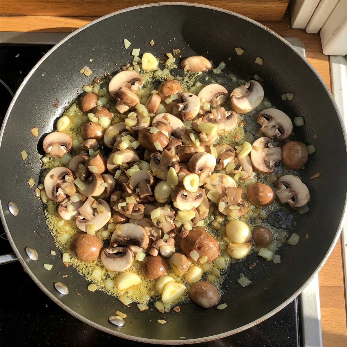 Sauteing mushrooms, onions, garlics in a frying pan.